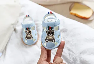 Détail de sandales bébé bleu clair avec motif ours et fermeture velcro réglable