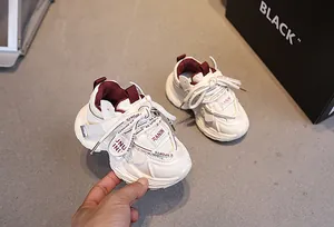 Top view detail of cream and burgundy kids sneakers with breathable mesh and thick soles