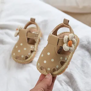 Sandales bébé fille beiges à pois blancs avec décoration florale et semelle souple