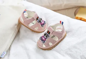 Détail de sandales roses pour bébé avec décoration d'ours et bout fermé respirant doux