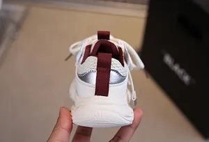 Close-up of children's mesh sneaker heel with burgundy lining and silver trim