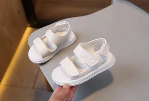 Dettaglio di sandali bianchi per bambini con doppia chiusura a strappo e suola antiscivolo