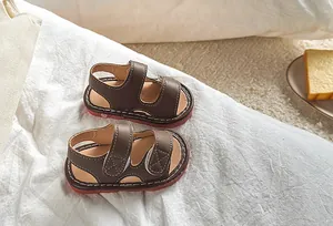 Détail macro de sandales marron pour tout-petits avec scratchs et semelles rouges antidérapantes
