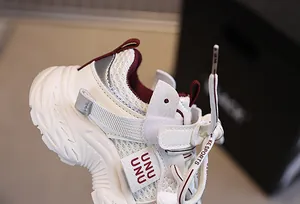 Detailed close-up of kids breathable mesh sneakers with burgundy lining and silver accents