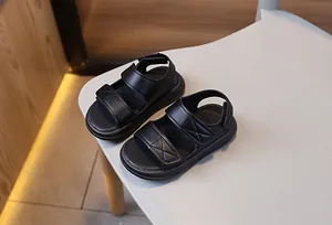 Dettaglio dei sandali neri per bambini con doppia fascia e chiusura in velcro