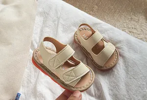 Vue détaillée de sandales pour bébé crème avec semelle antidérapante orange et velcro