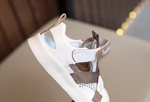 Detail view of breathable mesh and Velcro strap on beige toddler summer sandals