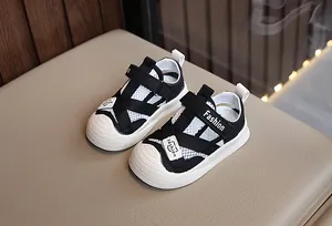 Detail view of breathable white mesh upper and black velcro straps on toddler sandals