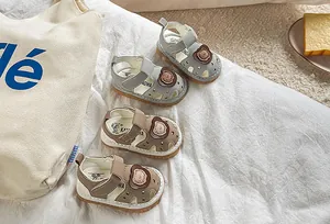 Detail of infant sandals with bear patch and star cutouts on soft rubber soles