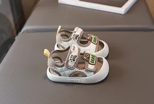 Nahaufnahme von Babysandalen mit Bärenmotiv, Rautensteppung und Klettverschluss-Riemen