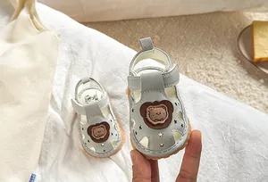 Detail of baby summer sandals with a cute bear motif and breathable star cutouts