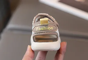 Detailansicht der Baby-Strandsandale in Creme und Braun mit gelber Fersenschlaufe