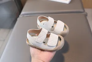 Nahaufnahme der Baby-Sandalen mit Klettverschluss und weicher Gummisohle für Schutz