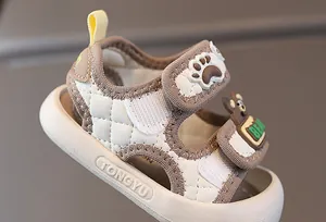 Details von Kleinkind-Ledersandalen mit Steppmuster und Klettverschluss mit Bärenmotiv