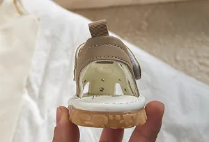 Detail view of khaki baby sandal with soft anti-slip rubber sole and heel pull tab