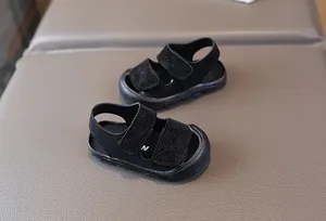 Nahaufnahme von strapazierfähigen schwarzen geschlossenen Kinder-Sandalen mit Klettverschluss
