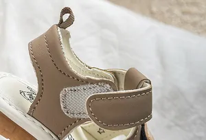 Detailed macro view of infant sandals featuring premium faux leather and velcro closure