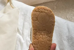 Close-up of baby walking shoe sole with anti-slip puzzle patterns and cartoon design