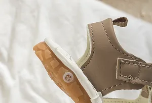 Detail of baby summer sandal showing brown leather stitching and anti-slip rubber sole
