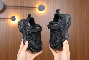 Close-up of black breathable mesh kids' sneakers with a hook-and-loop closure strap