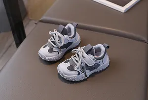 Detail of children's grey sneakers featuring breathable mesh and velcro straps