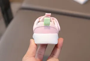Close-up of pink baby walking shoe heel with breathable mesh and green pull tab