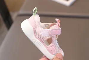 Detail of pink baby sandal with breathable mesh, velcro strap, and protective toe cap