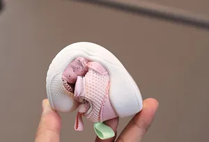Detailed close-up of pink baby sandal showing a flexible soft sole being bent for comfort
