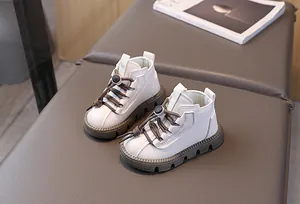 Detail shot of white leather kids' Martin boots with non-slip brown rubber soles