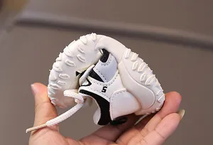 Close-up of flexible rubber sole being bent on kids white breathable trainers