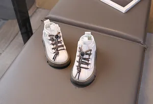 Detailed close-up of cream children's boots with brown laces and a secure toggle closure