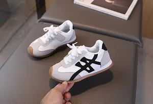 Dettaglio di sneakers per bambini beige e grigie con texture in pelle scamosciata e suola