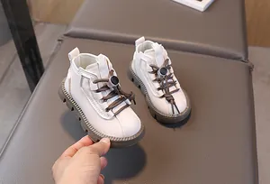 Detail of kids high-top boots featuring cream PU leather and adjustable toggle laces