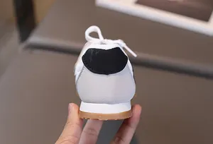 Dettaglio del tallone di sneaker per bambini con camoscio grigio e suola in gomma