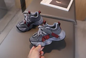 Detailed view of kids' gray chunky sneakers featuring burgundy straps and velcro straps