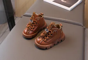 Detail of dark brown leather kids boots featuring a toggle lace and thick rubber sole