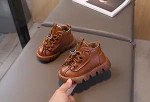 Detail view of brown leather kids' boots with durable non-slip rubber soles and soft lining