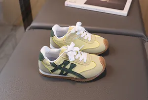 Dettaglio di scarpe sportive gialle per bambini con finiture in pelle verde e suola gomma