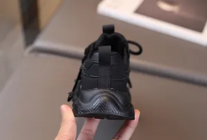 Detail view of the durable non-slip rubber sole and heel pull tab of kids sports sneakers