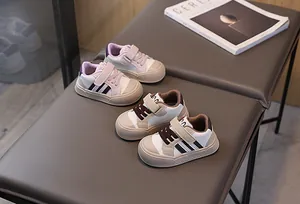 Detail view of toddler sneakers with velcro straps and anti-slip soles in neutral tones