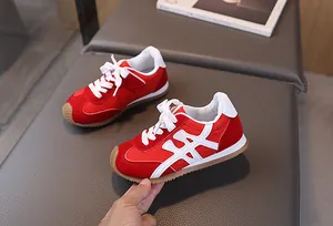 Dettaglio ravvicinato di sneakers rosse per bambini in camoscio con cucitura a X bianca