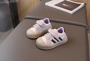 Detail view of toddler sneakers with purple contrast panels and hook and loop closure