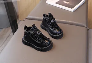 Detail view of black kids leather boots featuring white stitching and non-slip rubber soles