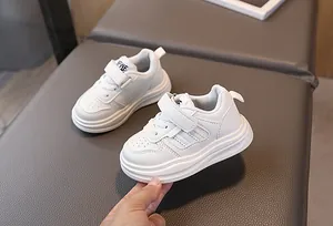 Détail de baskets blanches pour enfants avec fermeture velcro et semelle antidérapante