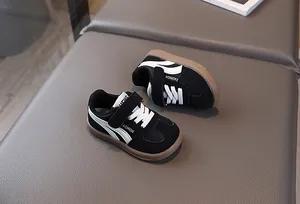 Detail view of children's black sneaker featuring retro gum sole and velcro strap