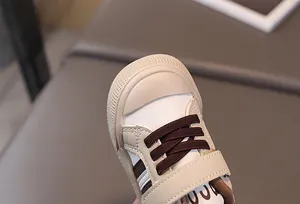 Detail of baby sneakers with rubber toe cap, velcro strap, and canvas leather splicing