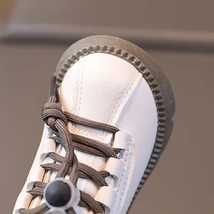White leather kids' Martin boots with grey non-slip rubber toes and adjustable toggles