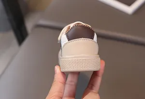 Close-up of the heel area and textured sole on kids' beige and brown patchwork sneakers
