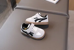 Detail view of toddler sneakers featuring black and white synthetic leather with gum sole