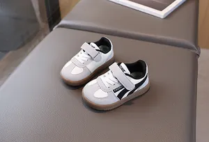 Detail view of children sneakers with velcro straps and brown non-slip rubber soles